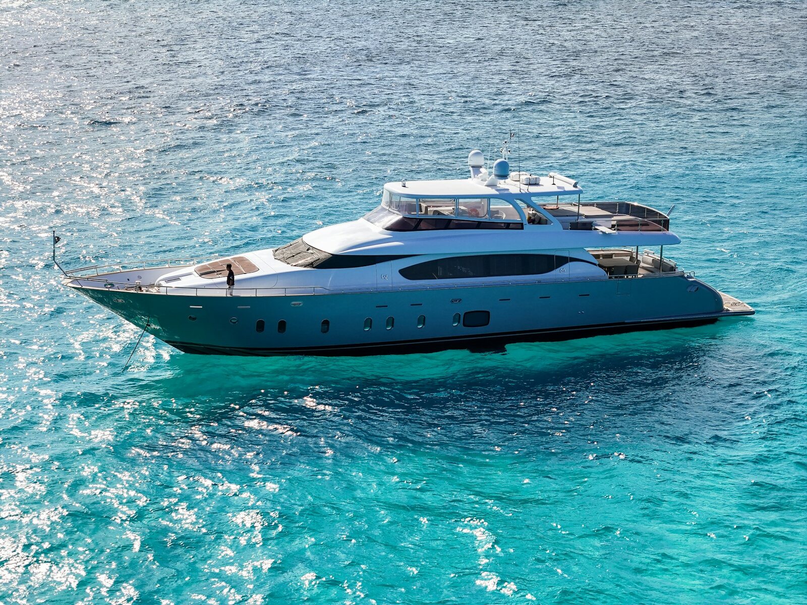 Luxury yacht anchored in clear tropical water for private concierge travel